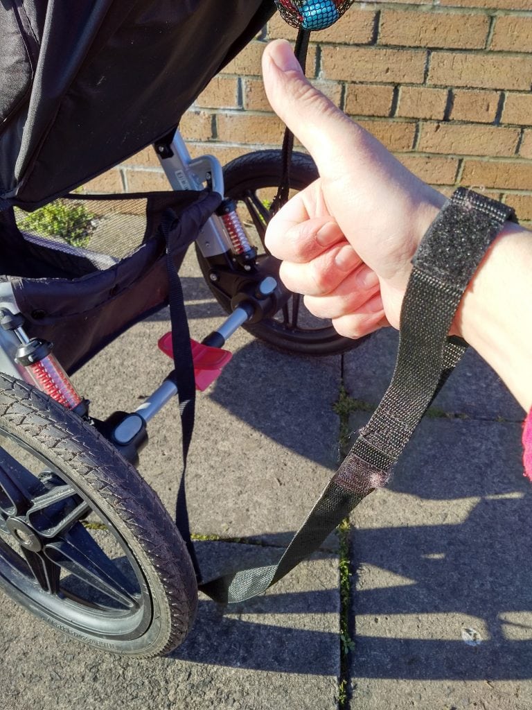 Aftermarket wrist tether looped around Graco Relay chassis